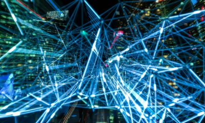 Dynamic urban scene showcasing interconnected light trails representing digital communication networks.