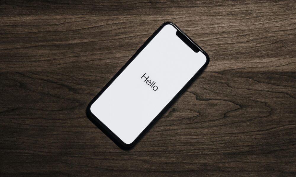 A smartphone displaying 'Hello' on a wooden surface, showcasing modern technology.