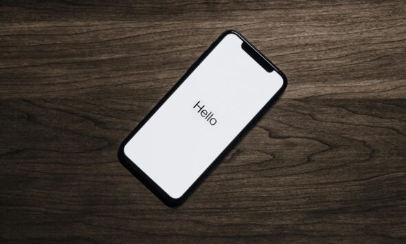 A smartphone displaying 'Hello' on a wooden surface, showcasing modern technology.
