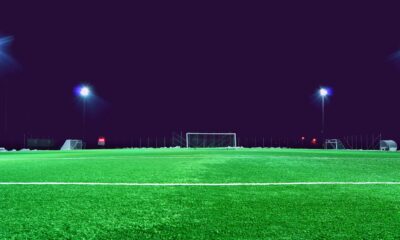 A brightly lit soccer field at night in Norrtälje, Sweden, showcasing green turf and stadium lights.
