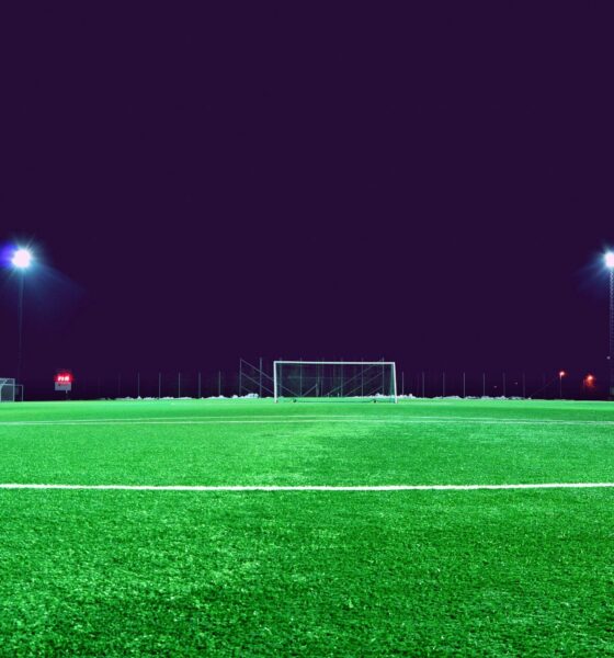 A brightly lit soccer field at night in Norrtälje, Sweden, showcasing green turf and stadium lights.